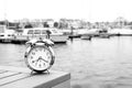 Vintage clock silver put on wood near port with background boat, sea and white sky in morning time, clock concept in holiday time Royalty Free Stock Photo