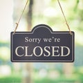 Vintage close sign board. Text written Sorry we`re closed sign hanging front of cafe mirror door.