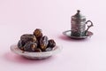 Vintage coffee cup and dry date fruits on pink background. Royalty Free Stock Photo