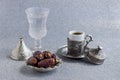 Vintage coffee cup,a glass of water and dry date fruits on shiny silver background. Royalty Free Stock Photo