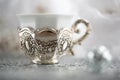 Vintage coffee silver cup and blurred light background with white bokeh. Soft focus. Antique white porcelain.