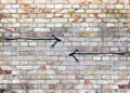 Vintage color brick wall with two opposite black arrows