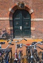 Vintage colorful bicycles opposite ancient door in old brick wall. Royalty Free Stock Photo