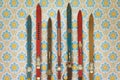 Vintage colorful used skis in front of retro wallpaper