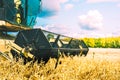 Vintage combine harvester working on oat field in summer