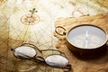 Vintage compass and glasses on antique map Royalty Free Stock Photo