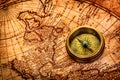 Vintage compass lies on an ancient world map.