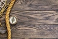 Vintage compass, magnifying glass and hawser rope on old wooden table with copy space