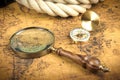 Vintage Compass and magnifying glass lies on an ancient world map - adventure stories background Royalty Free Stock Photo