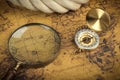 Vintage Compass and magnifying glass lies on an ancient world map - adventure stories background Royalty Free Stock Photo