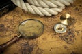 Vintage Compass and magnifying glass lies on an ancient world map - adventure stories background Royalty Free Stock Photo