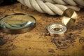 Vintage Compass and magnifying glass lies on an ancient world map - adventure stories background Royalty Free Stock Photo