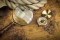 Vintage Compass and magnifying glass lies on an ancient world map - adventure stories background Royalty Free Stock Photo