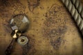 Vintage Compass and magnifying glass lies on an ancient world map - adventure stories background Royalty Free Stock Photo