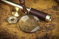 Vintage Compass, magnifying glass and spyglass telescope lies on an ancient world map - adventure stories background Royalty Free Stock Photo