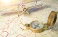 A vintage compass on the map and an airplane in the background. Royalty Free Stock Photo