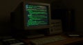 Vintage Computer with Green Code Screen in Dim Office Setting Royalty Free Stock Photo