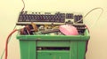 Vintage computer parts in a green plastic bin. An old keyboard, mouse, and miscellaneous electronic components, captured Royalty Free Stock Photo