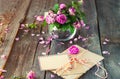 Vintage concept - bouquet of wilting tea roses in vase, pile of old letters in envelopes and blank greeting card on the old wooden Royalty Free Stock Photo