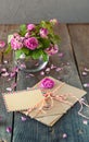 Vintage concept - bouquet of wilting tea roses in vase, pile of old letters in envelopes and blank greeting card on the old wooden Royalty Free Stock Photo