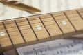 conceptual composition of notes, wooden guitar and sound board a golden bird`s feather is on a sheet of old yellowed and Royalty Free Stock Photo
