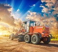 Vintage construction tractor on wheels standing eddge of road beautiful sunset view