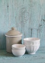 Vintage cookware - enameled jar and white ceramic bowl on a blue wooden surface Royalty Free Stock Photo