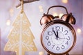 Vintage Copper Alarm Clock Showing Five Minutes to Midnight. New Year Countdown. Wood Christmas Tree Ornament Hanging on Branch