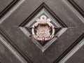 Vintage copper door knocker on an old oak wooden door. Close up front view horror house concept for 31 October Royalty Free Stock Photo