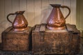 Vintage copper jugs standing on wooden crates with Bushmills whiskey bandings