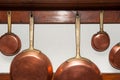 Vintage copper pans hung on wooden shelf Royalty Free Stock Photo