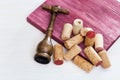 Vintage corkscrew and heap used wine corks on wooden background. Spin and stopper corks from red wine Royalty Free Stock Photo