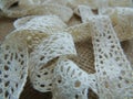 Vintage cotton cream lace on burlap background.