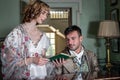 Vintage couple in period costume sitting around piano playing tunes and singing songs