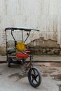 Vintage covered bicycle taxi parked in street, Havana, Cuba