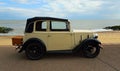 Vintage Cream Coloured Austin Seven with basket on back Parked on Seafront Promenade.