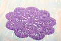 Vintage crochet round purple cotton lace doily with delicate ornament on light wood background. Needlework. Concept of self- Royalty Free Stock Photo