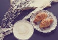 Vintage cup of cappuccino and croissants