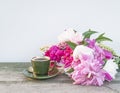 Vintage cup of coffee and bouquet ofn puprle peonies