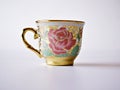 Vintage cup of tea with saucer isolated on white background ,Antique tea cup with golden rose pattern English style Royalty Free Stock Photo