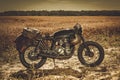 The vintage custom cafe racer in a field.