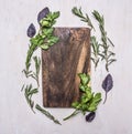 Vintage cutting board with herbs on wooden rustic background top view close place for text, frame Royalty Free Stock Photo