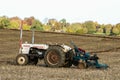 A vintage david brown white tractors with plough