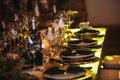 Vintage decoration of reception dinner table. Rustic wedding table setting in fancy European restaurant. Wine glasses, plates,