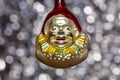 Vintage decorative christmas bauble in a shape of a crown jester against a silver bokeh blury star background