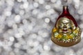 Vintage decorative christmas bauble in a shape of a crown jester against a silver bokeh blury star background