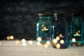 vintage decorative magical mason jars with candle light on wooden table Royalty Free Stock Photo