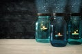 vintage decorative magical mason jars with candle light on wooden table Royalty Free Stock Photo