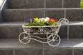 Vintage decorative metal flower-stand with flowers on stairs of a house Royalty Free Stock Photo