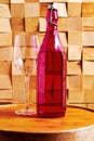 Vintage decorative wine bottle with red wine and glass on the wooden table